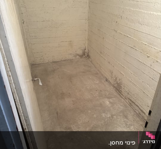 חדר ריק עם קירות בטון ודלת פתוחה